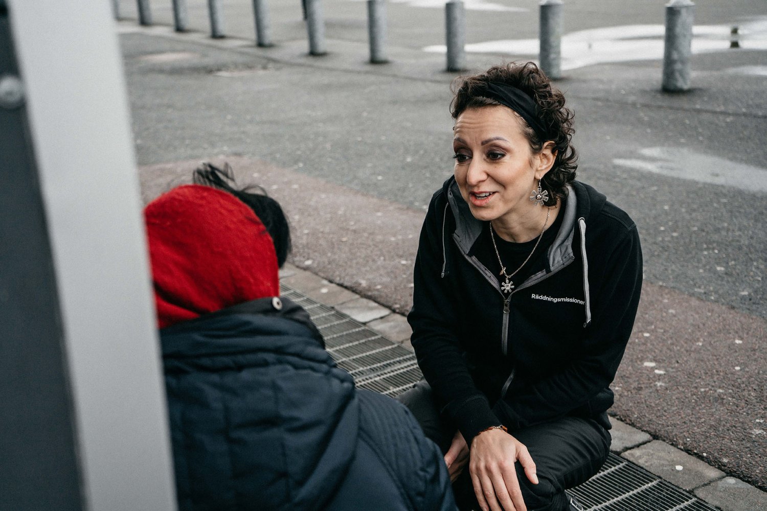 Medarbetare på Räddningsmissionen i Göteborg sitter ner på huk och pratar med en kvinna i utsatthet.