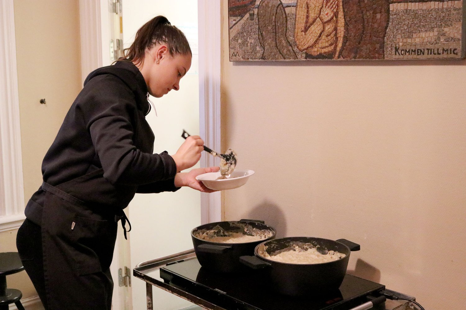 Volontär i Göteborg serverar gröt på Räddningsmissionens frukostcafé för hemlösa.