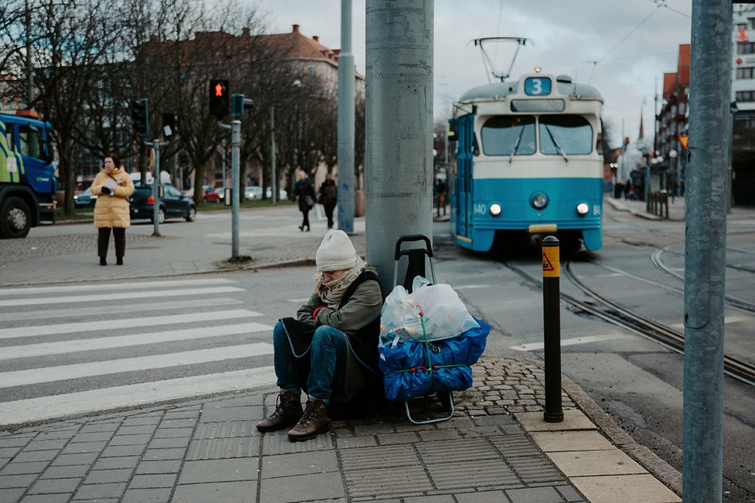 En kvinna i utsatthet sitter på gatan och fryser i Göteborg.