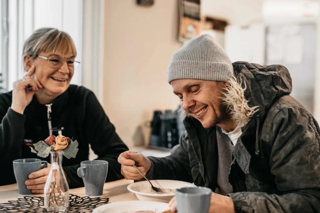 glad personal och gäst vid frukostbordet på frukostcaféet