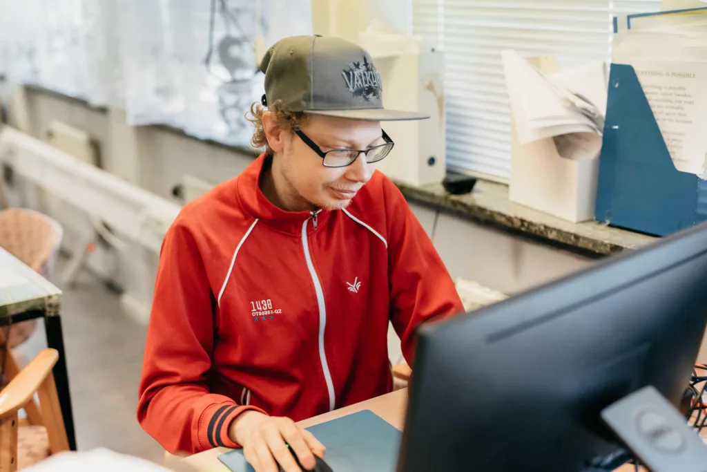 Deltagare på Mediatorgets dagliga verksamhet sitter vid datorn.