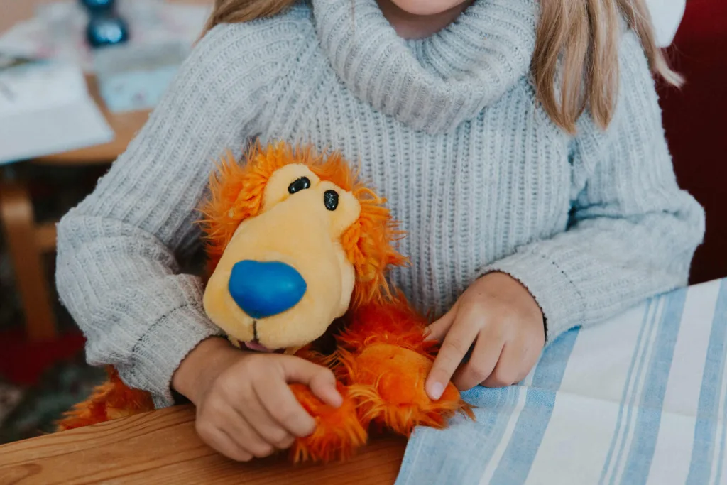 Barn sitter med sitt gosedjur på ett av Räddningsmissionens trygga boenden.