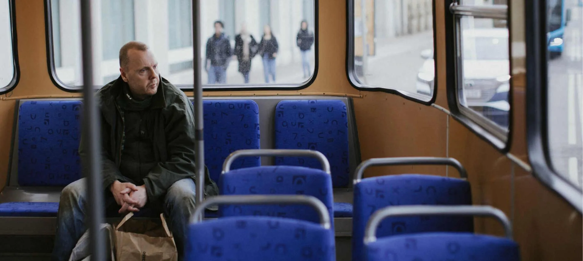 Man i hemlöshet på spårvagn. Arbete mot hemlöshet är en del i vårt arbete som insamlingsorganisation.